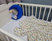 Load image into Gallery viewer, Thin muslin blanket in white with animals and white pom pom ball ribbon